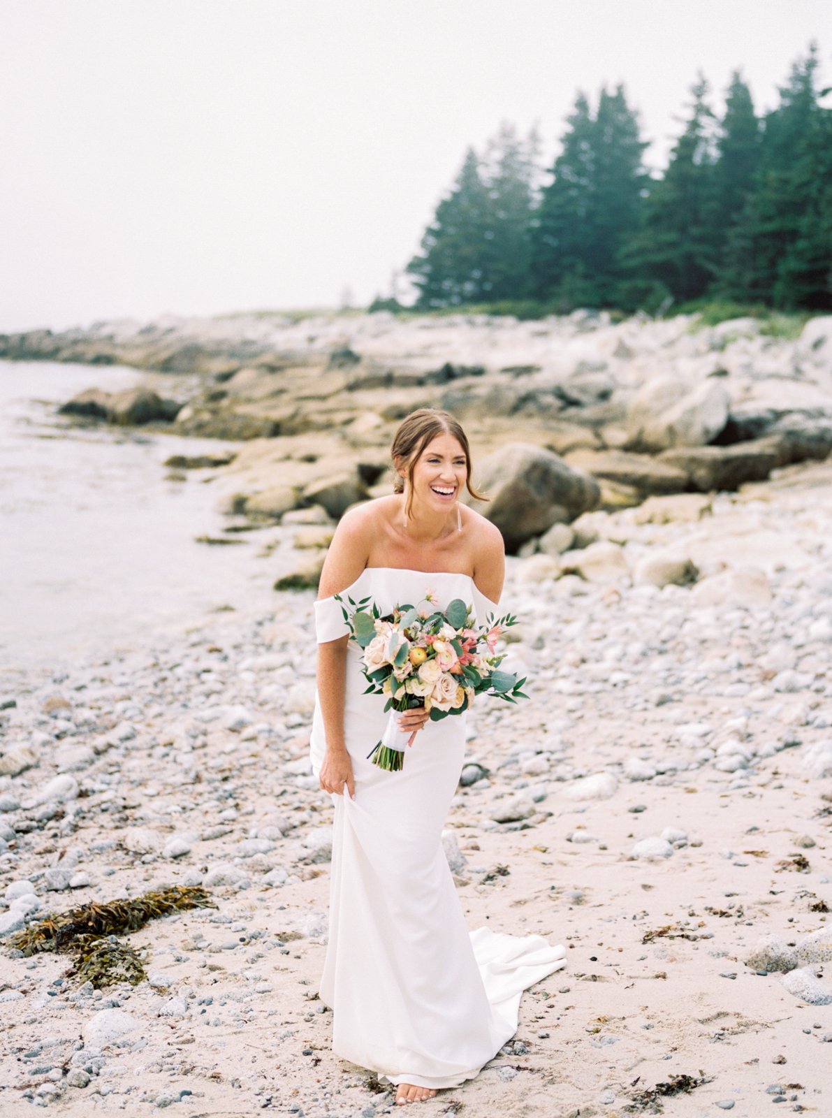  Bride holding bouquet standing on beach at Oceanstone Seaside Resort 