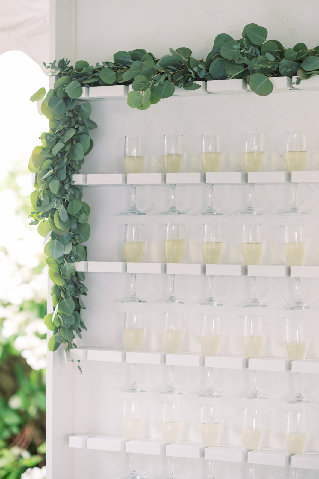  White wooden champagne wall with eucalyptus greenery garland at Oceanstone Seaside Resort wedding 