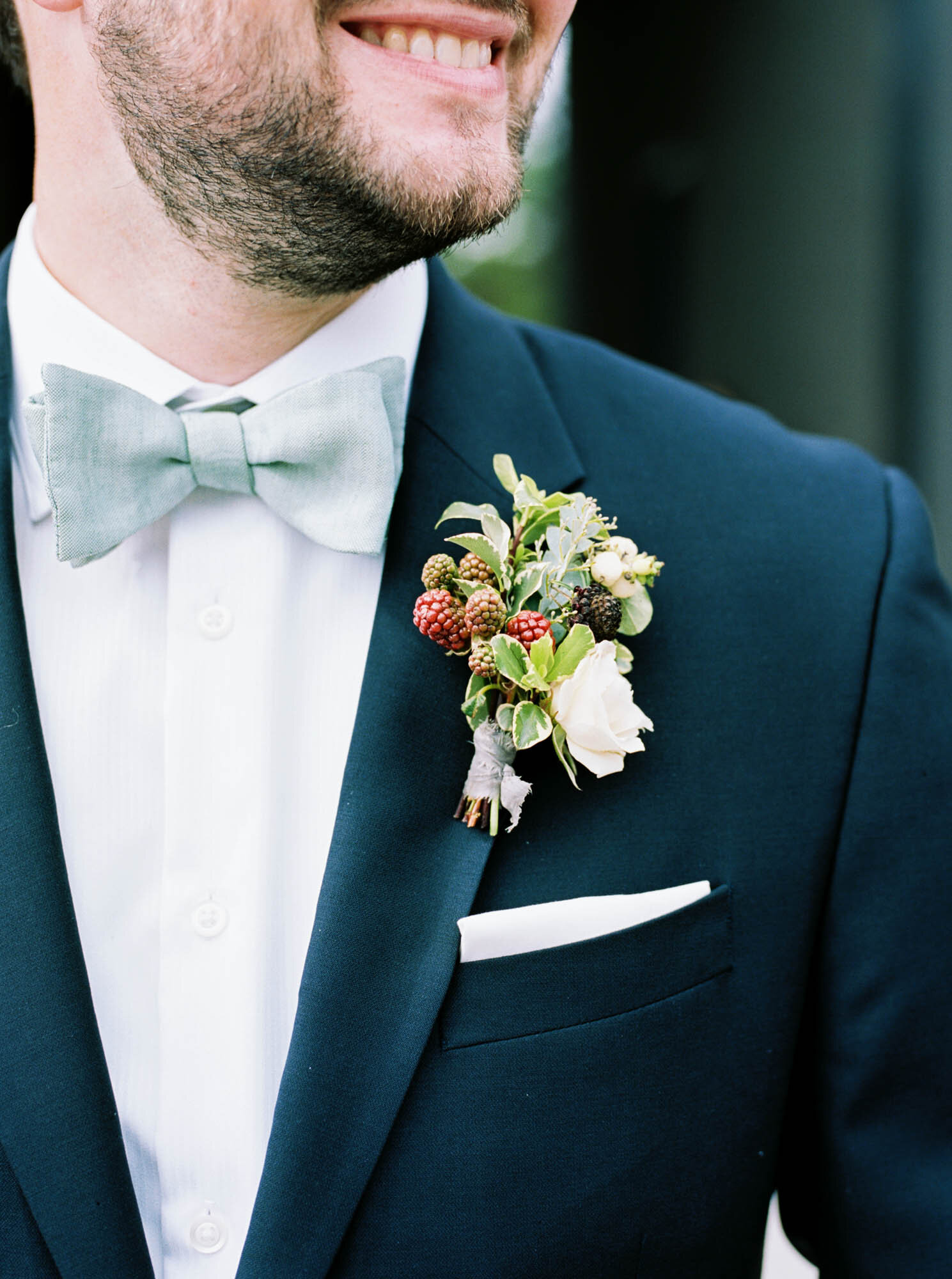  Blackberry &amp; floral boutonniere on groom with navy suit and light blue bowtie 