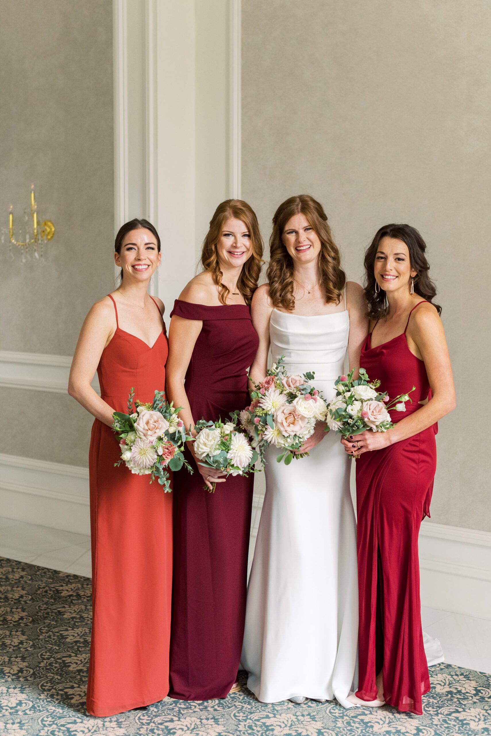 Bridesmaids in different warm tone dresses
