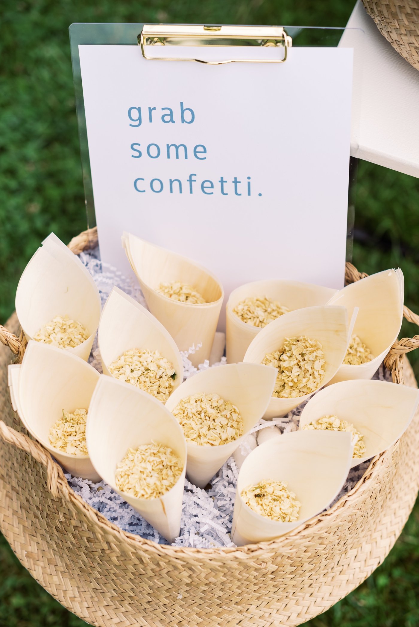 Woven seagrass basket filled with confetti cones at a wedding ceremony