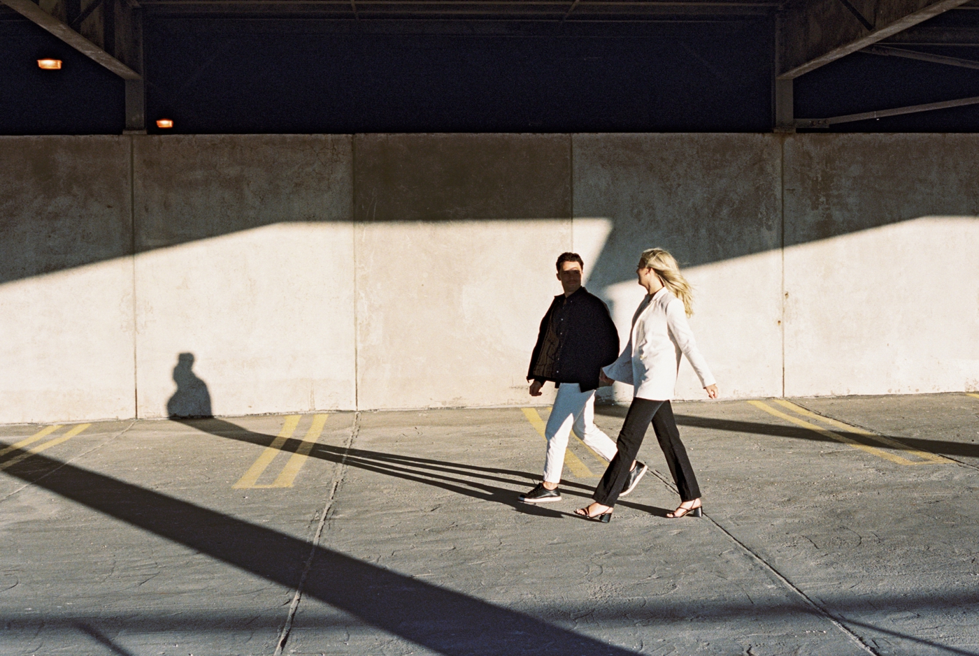 Couple walking in sunshine in parking garage
