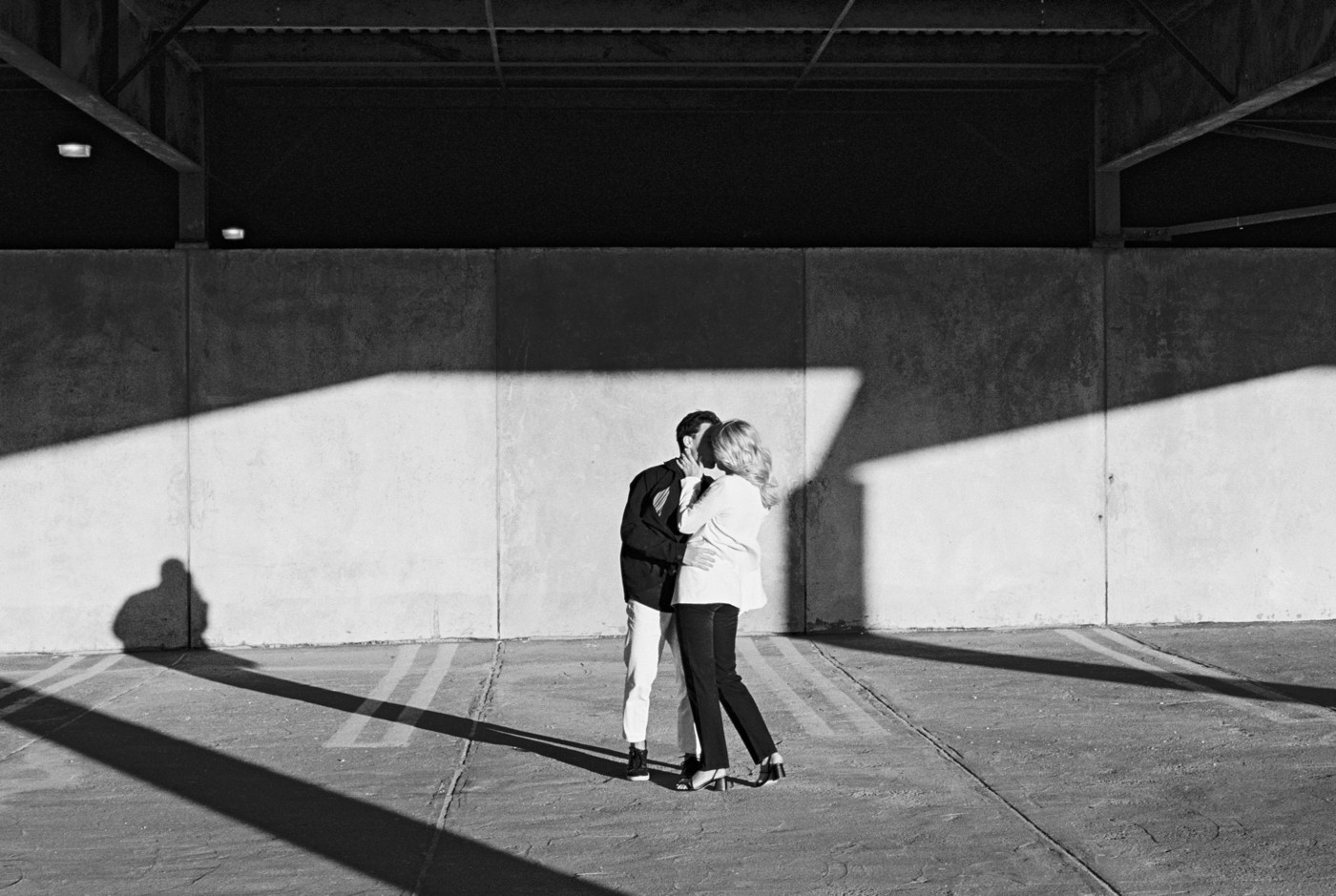 Black & white photo of couple kissing in parkade