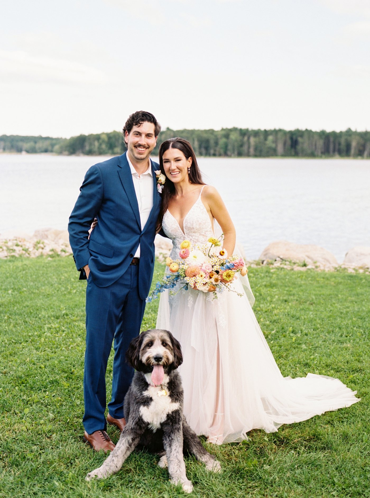 Bride and groom posing with their dog for portraits at Oak Island Resort