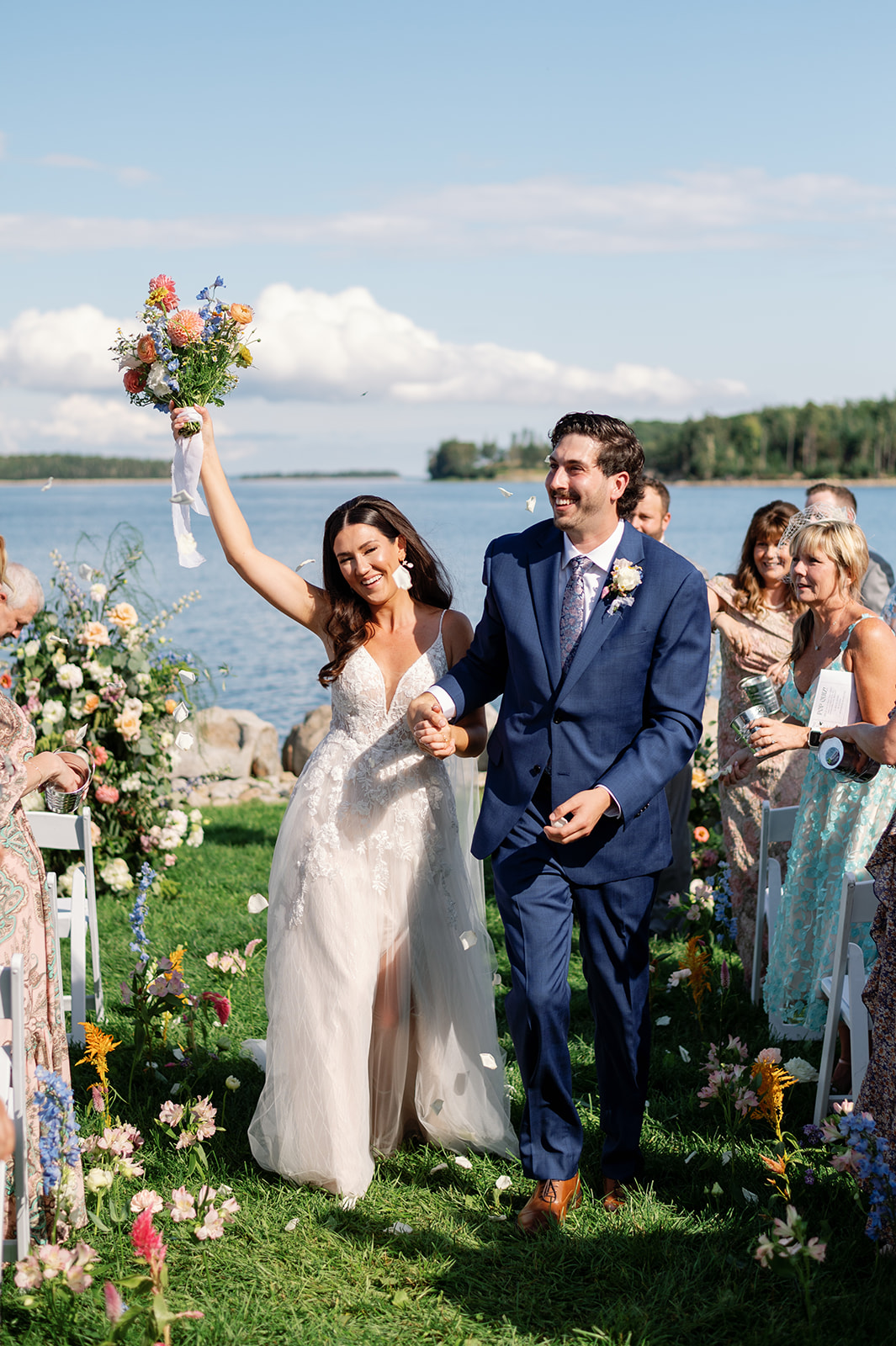 Bride and groom walking back up ceremony aisle, smiling, capturing the best time of year to get married in Nova Scotia.